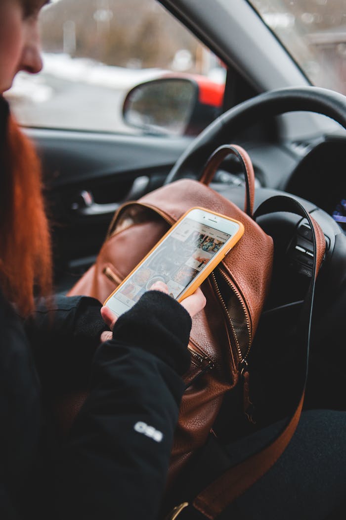 Female driver using smartphone in car